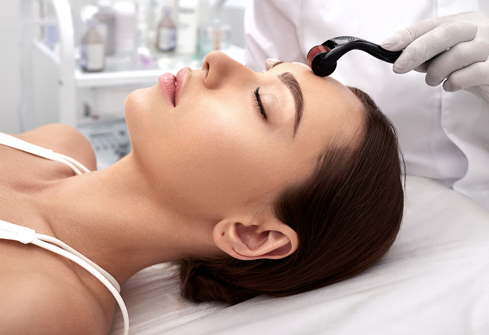 beautician,doing,skin,treatment,using,a,microneedle,dermaroller.,woman,having