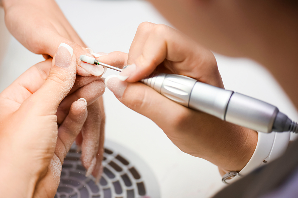 woman,use,electric,nail,file,drill,in,beauty,salon.,perfect